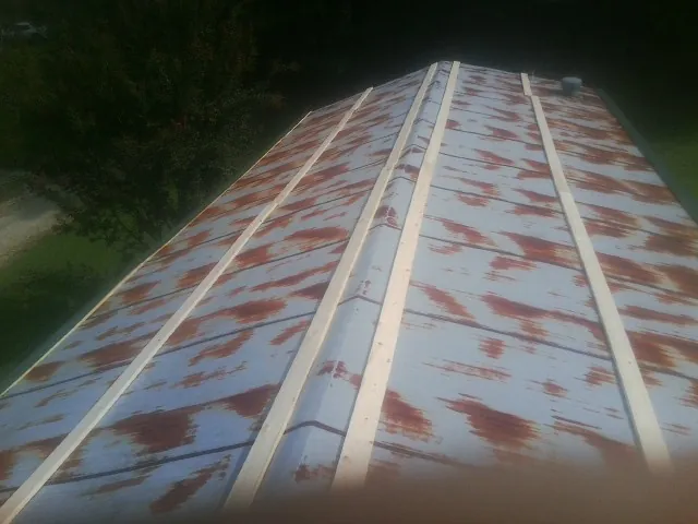 Rusted metal roof panels with new wood purlins before replacement — Storm Damage Roof Repair in Louisburg by Roofing Brothers